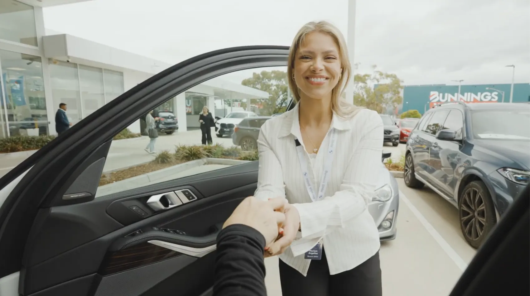 JMG Used Cars team member helping a customer inspect a used car in Victoria